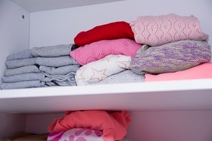 Sweaters on top shelf of closet 