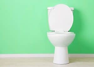 White toilet with mint green wall