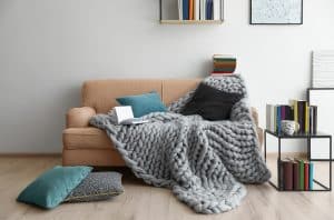 College Apartment Living Room with Sofa, End Table, and Books