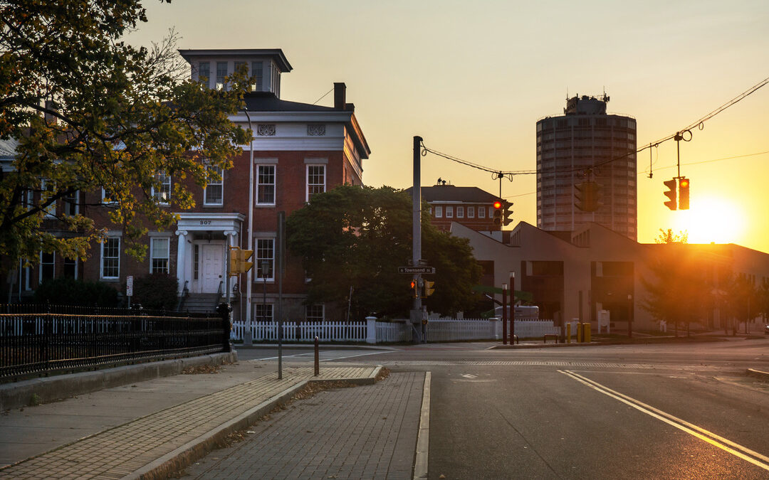 The sun sets behind a scene similar to Court Street apartments in Athens, Ohio.