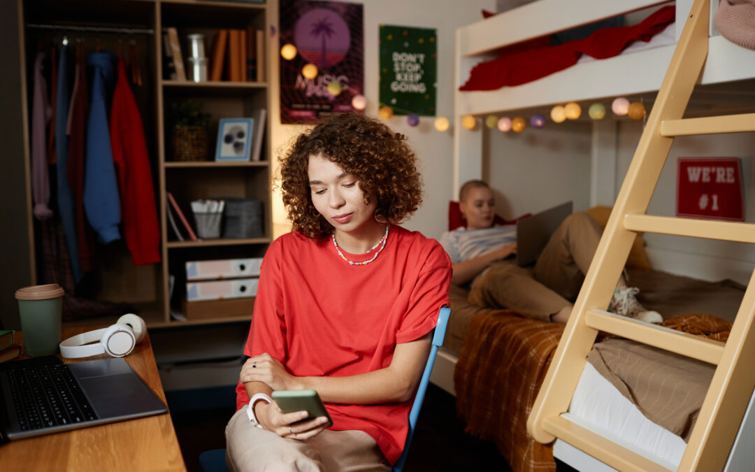 Young Woman Using Smartphone in Dorm Room to set boundaries